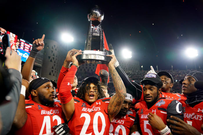 Cincinnati Bearcats linebacker Deshawn Pace (20) raises the trophy of the American Athletic Conference championship football game, Saturday, Dec. 4, 2021, at Nippert Stadium in Cincinnati. The Cincinnati Bearcats defeated the Houston Cougars, 35-20. Houston Cougars At Cincinnati Bearcats Aac Championship Dec 4